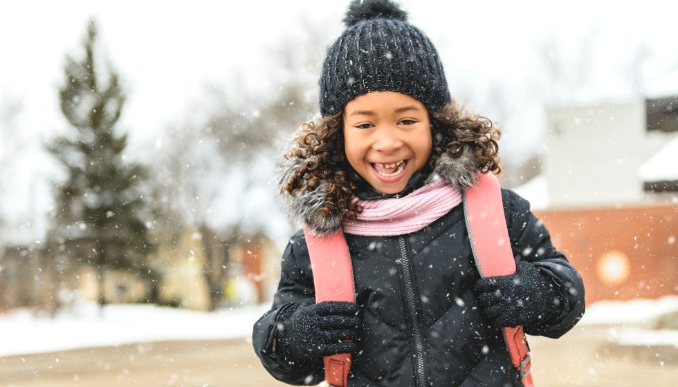 child in front of school winter